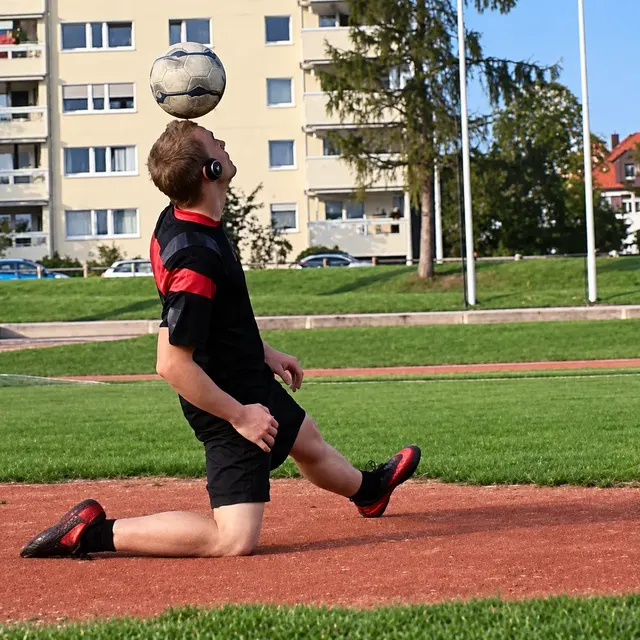 Ball auf dem Kopf kniend