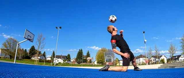 Ball über dem Kopf auf blauem Platz