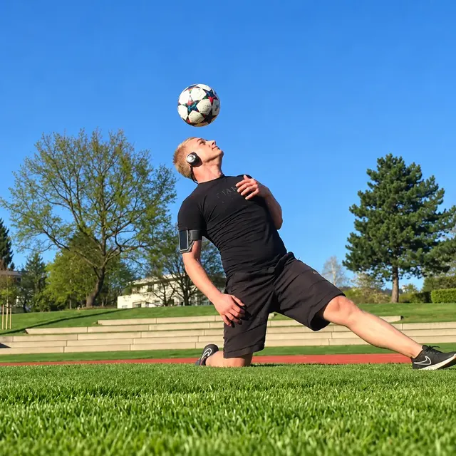 Ball auf dem Kopf auf Rasen